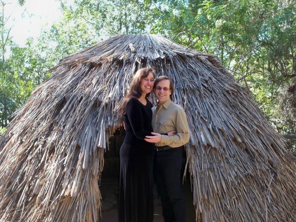 In front of a native hut replica